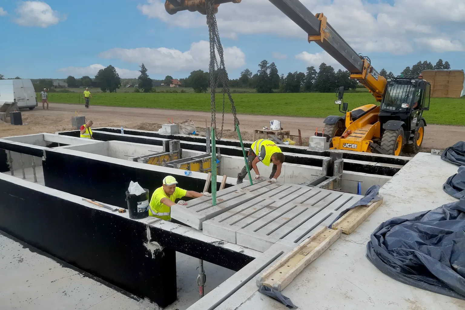 pracownicy firmy kanus montują płyty betonowe